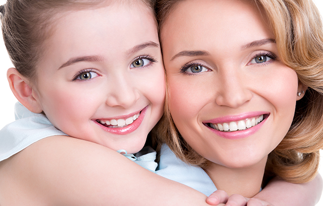 CLoseup portrait of happy  white mother and young daughter - isolated. Happy family people concept.
